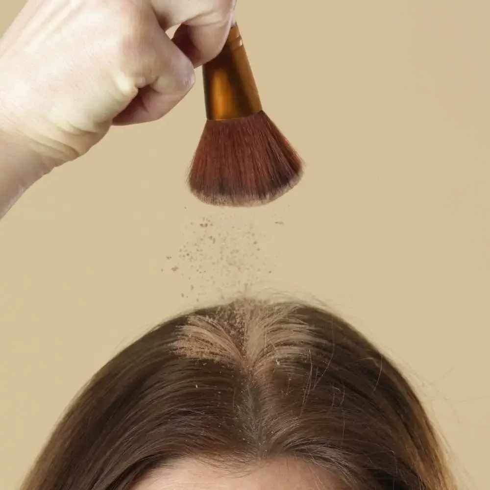 Woman rejuvenating her hair with a spritz of dry shampoo