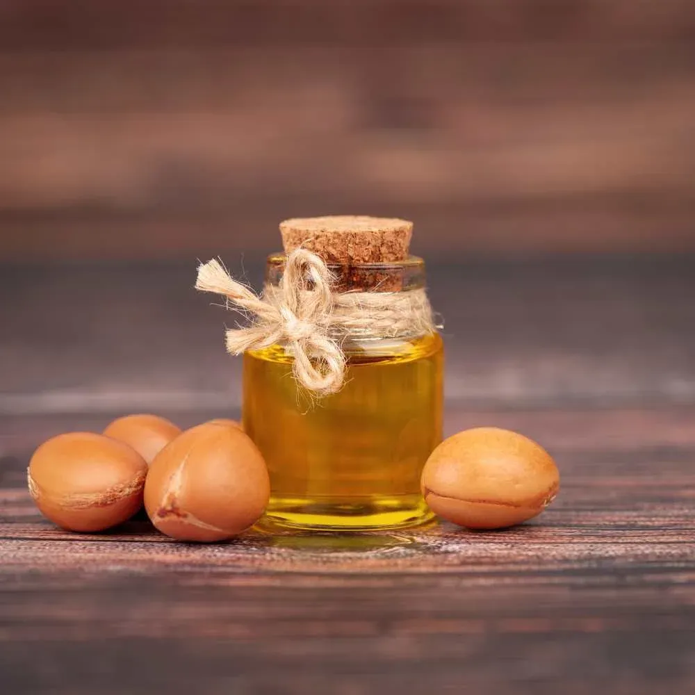 Pure Argan Oil in a glass bottle on a wooden table