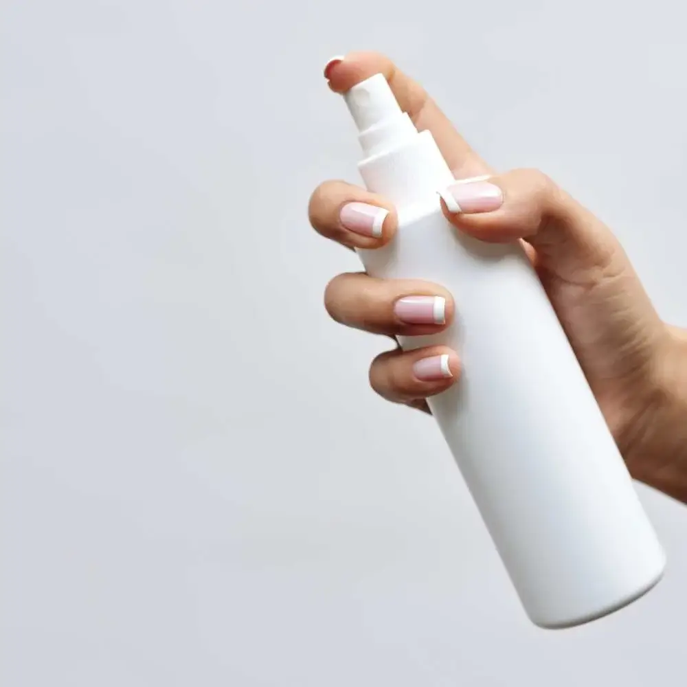 holding a hair spray bottle