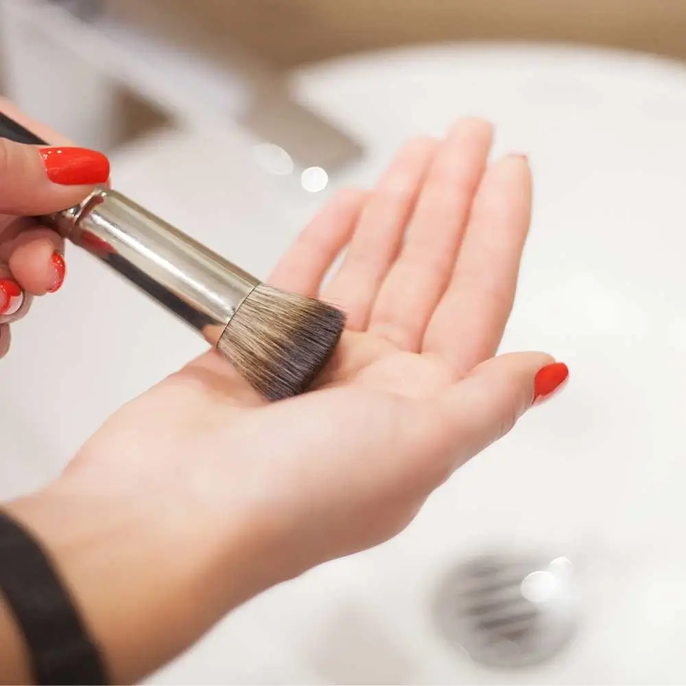 Thoroughly cleaning makeup brushes to maintain hygiene