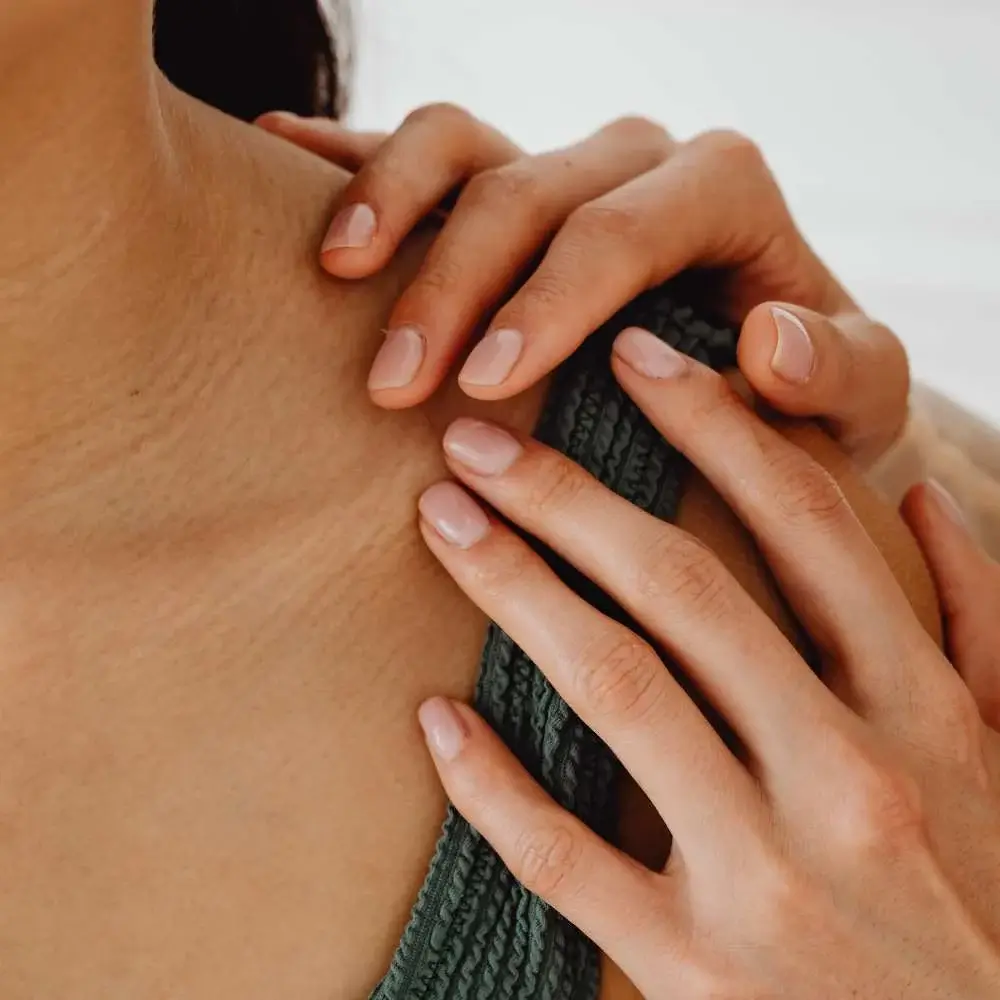 Model showcasing a glossy nude manicure, complementing her skin tone