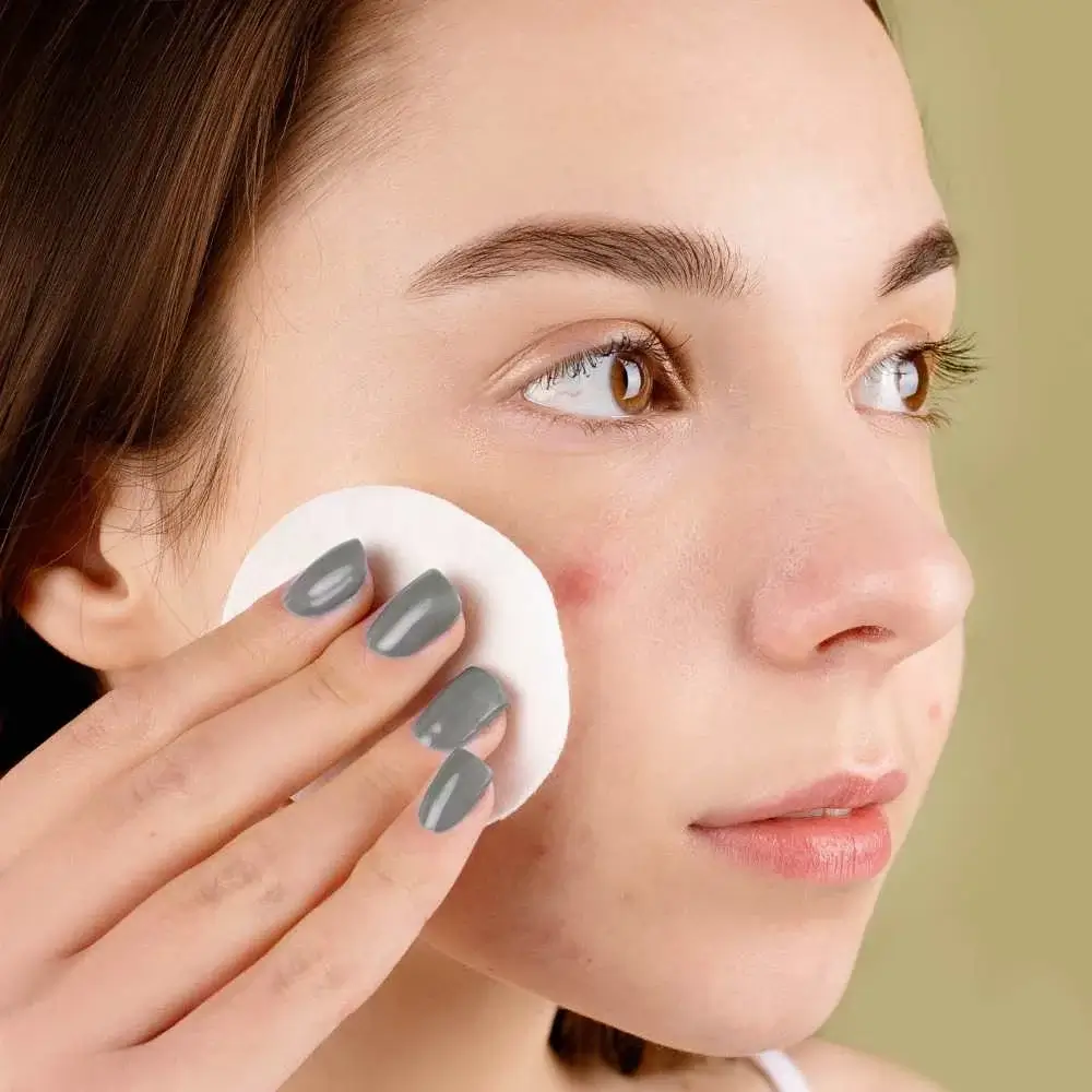 Woman happily applying Korean acne skincare