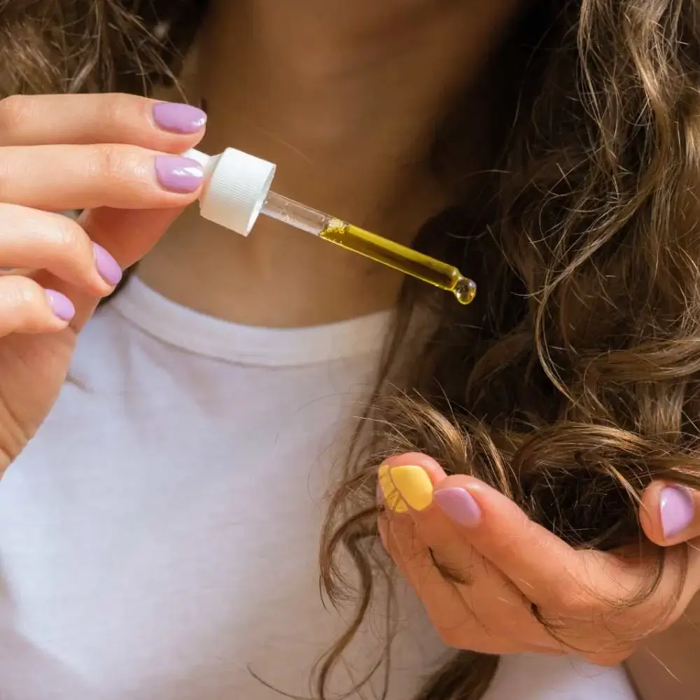 Golden argan oil in a glass bottle, ready to revitalize hair