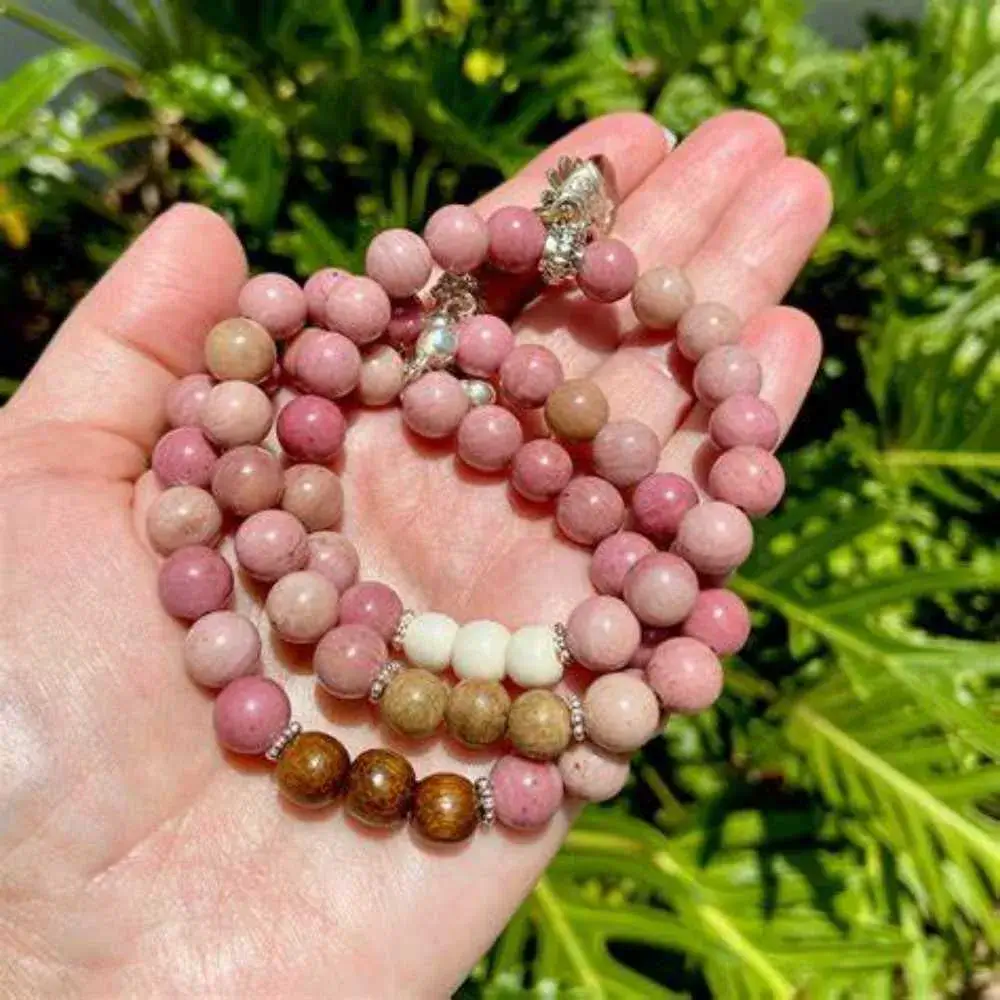 hand holding rhodonite bracelets