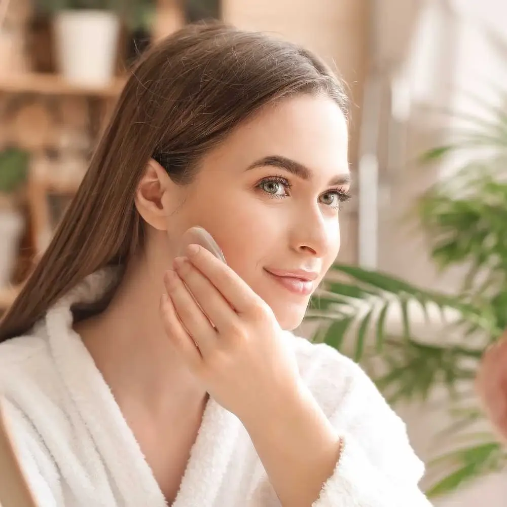 beautiful woman applying bronzer in front of the mirror