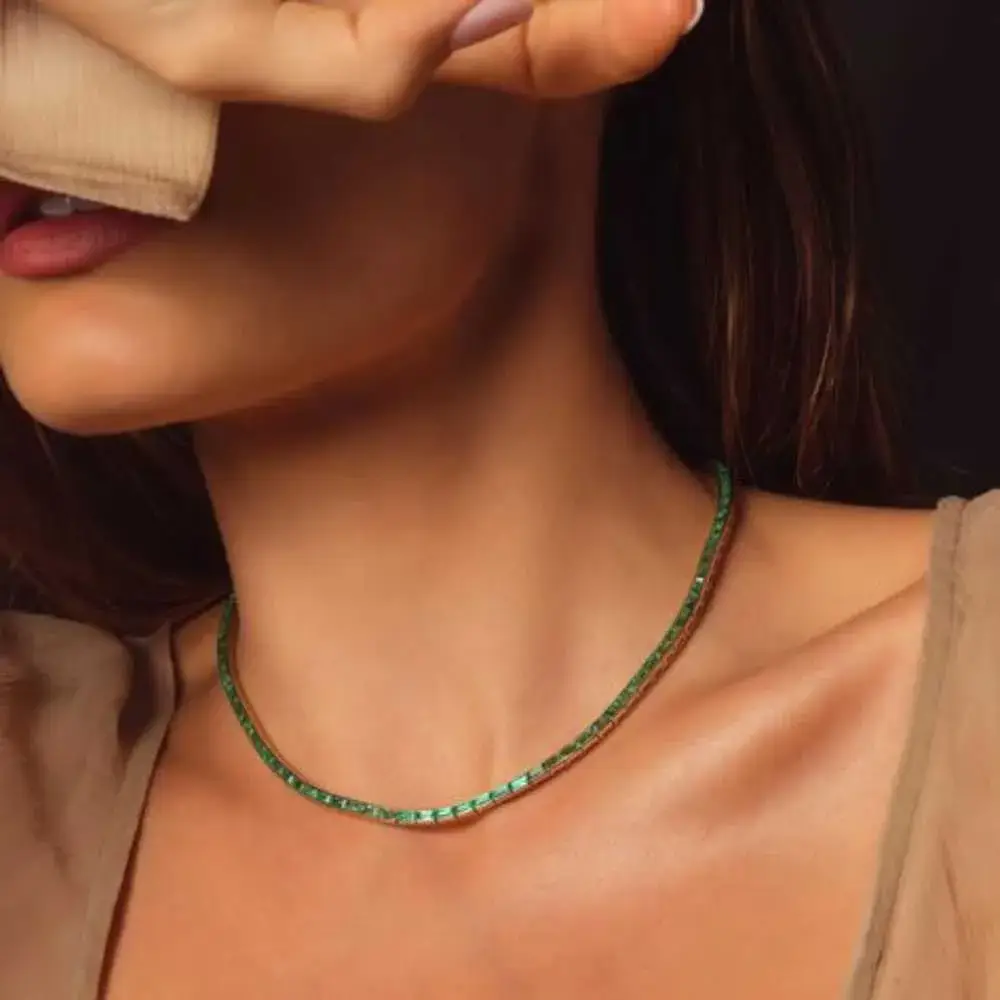 close-up view of  emerald tennis necklace on a young woman's neck 