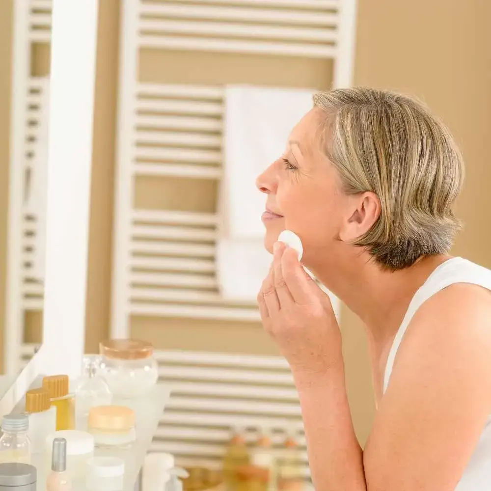 woman cleaning her face using a cotton pad