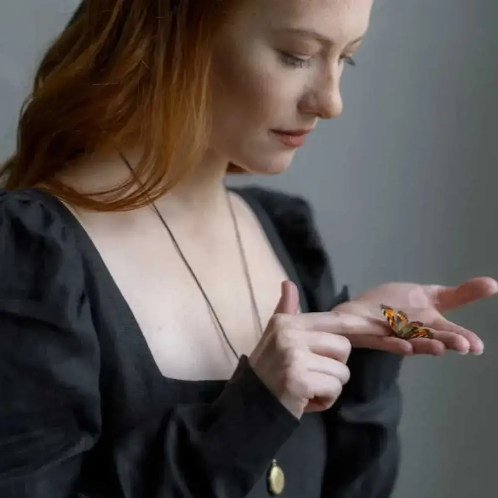 brunette woman in a black dress wearing a necklace