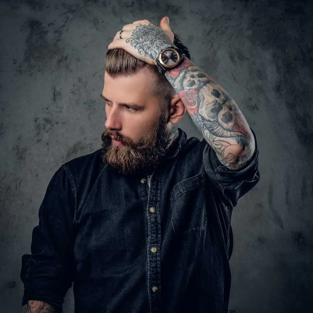 bearded young man with tattoos on his arm