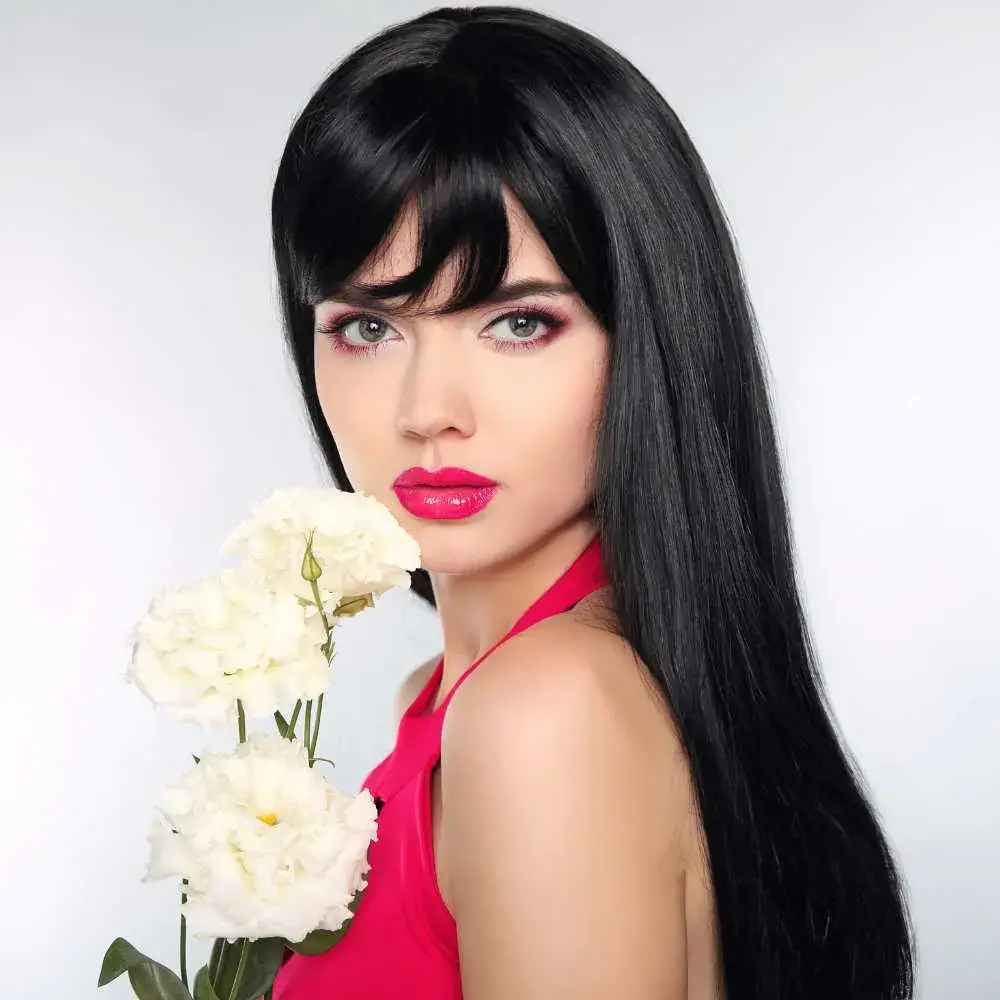 portrait of a young woman with long black hair and makeup holding white flowers