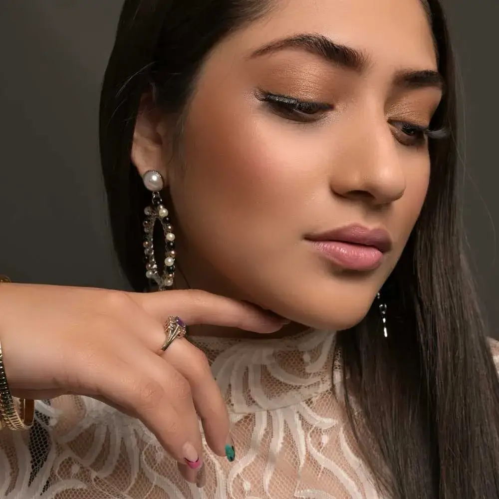 closeup side view portrait of a young woman wearing dangling earrings