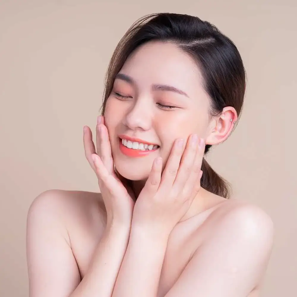 young asian woman with fresh skin smiling with eyes closed