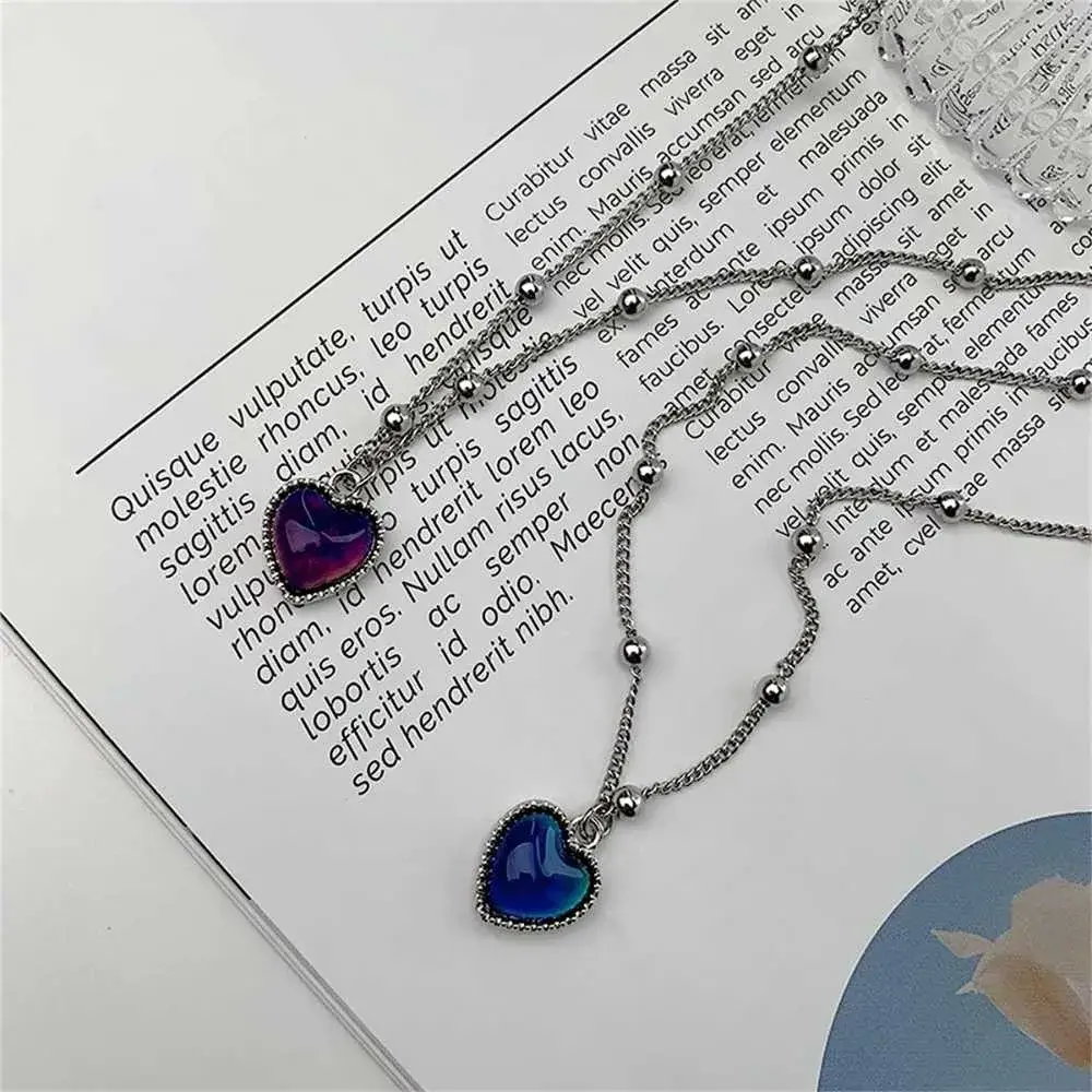 two silver necklaces with color changing heart pendants