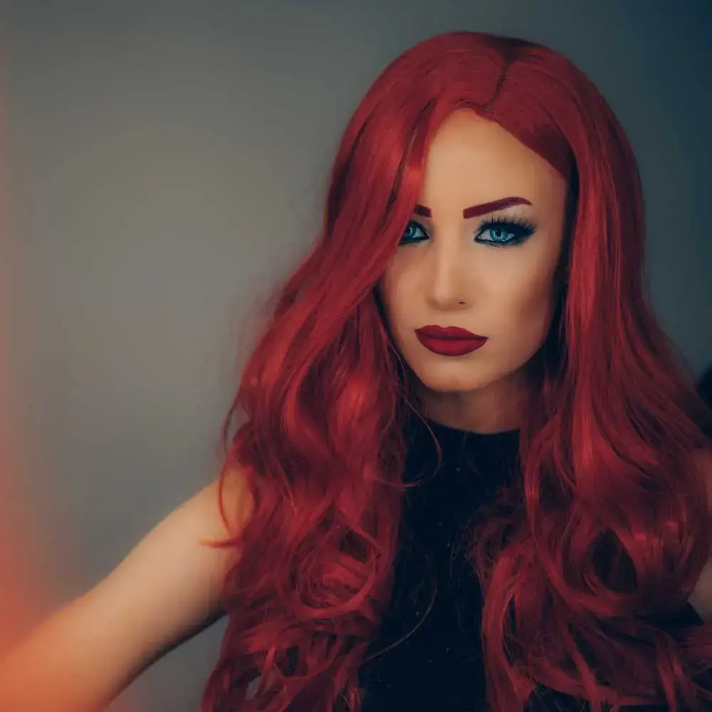woman wearing a long red human hair wig and red lipstick