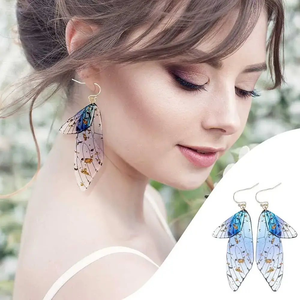 portrait of a young woman with makeup wearing blue butterfly wings drop earrings