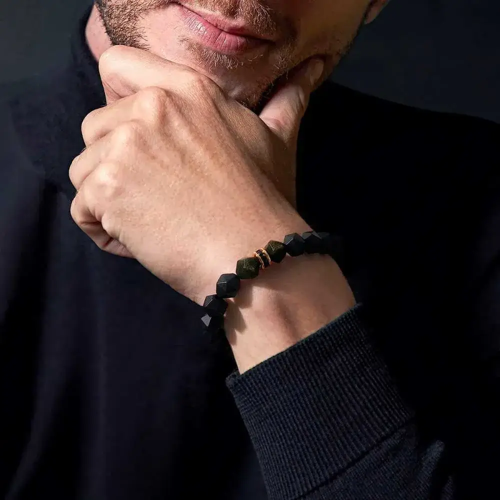 close-up view of a man's wrist with black beaded bracelet