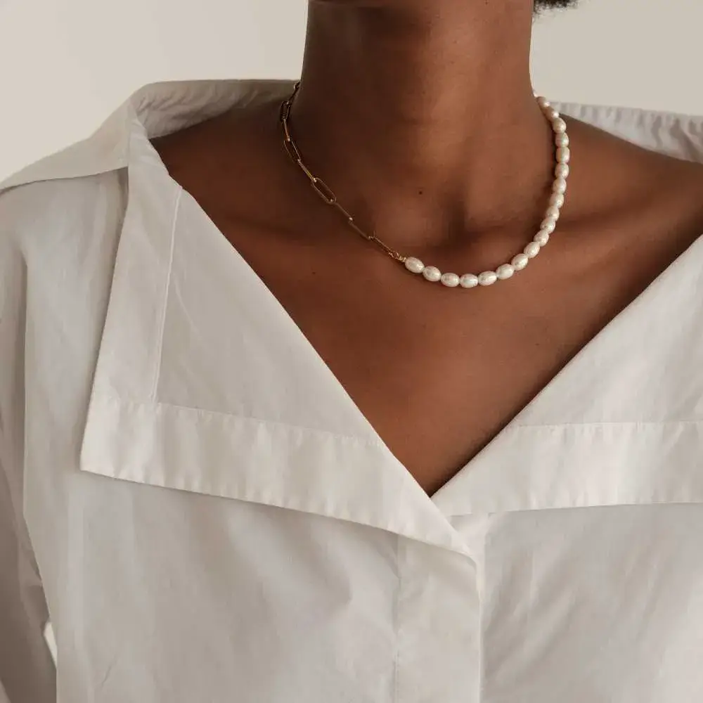 closeup of woman's neck with half chain half pearl necklace