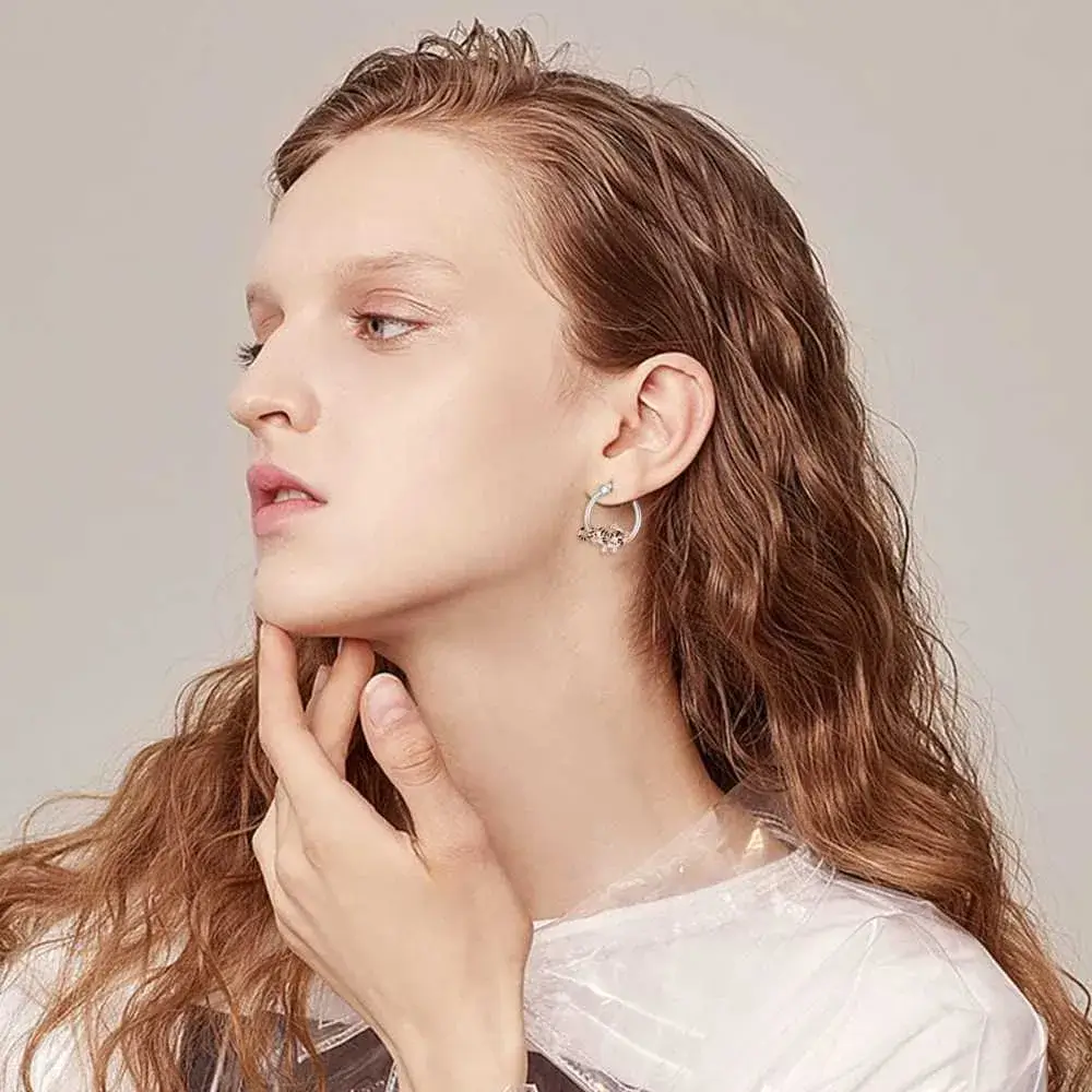 side view portrait of a woman with brunette hair wearing tiger earrings