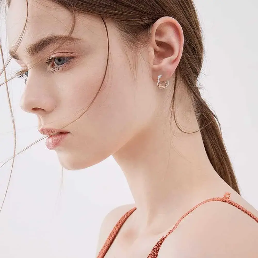 close-up side view portrait of a woman wearing heart tiger earrings