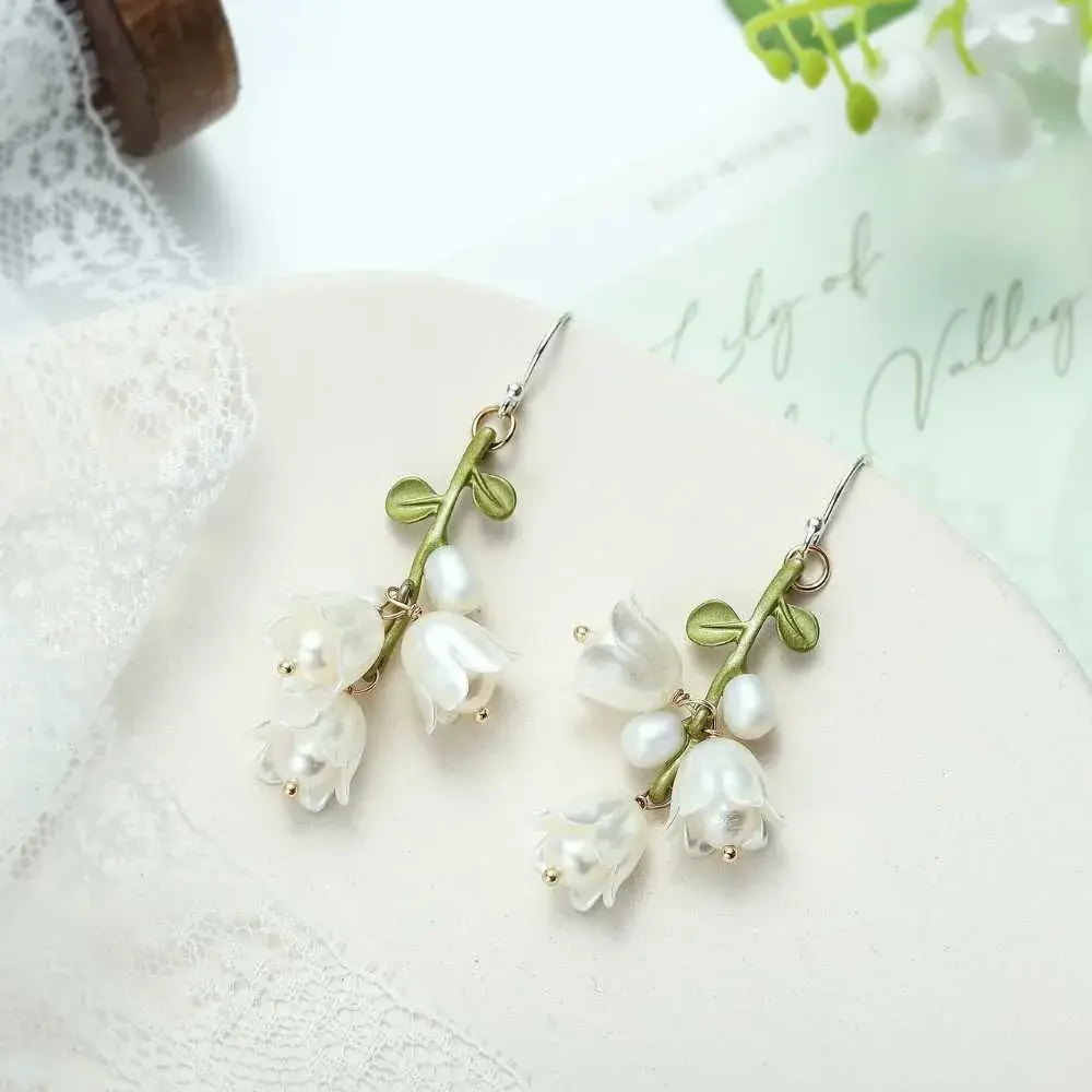pair of lily of the valley earrings on a white cloth