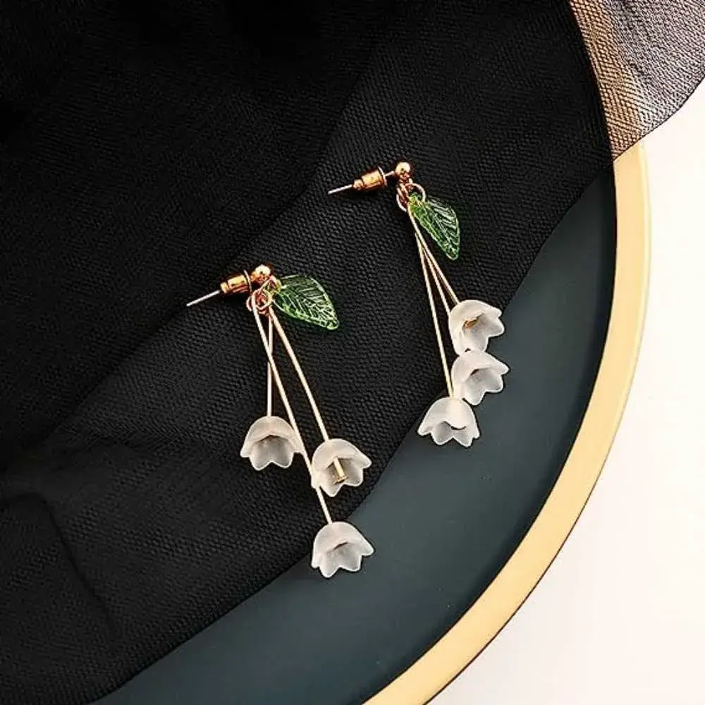 pair of lily of the valley earrings on a black jewelry case