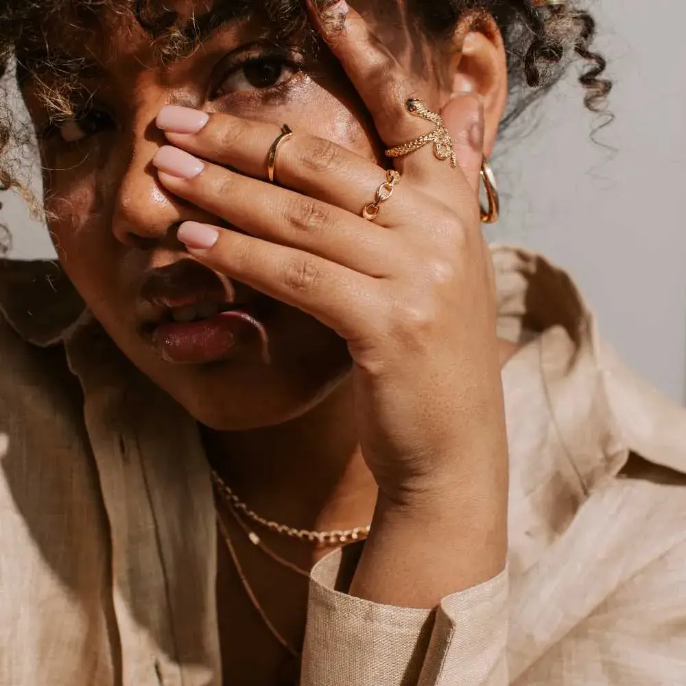 close-up portrait of a curly woman wearing different pieces of jewelry