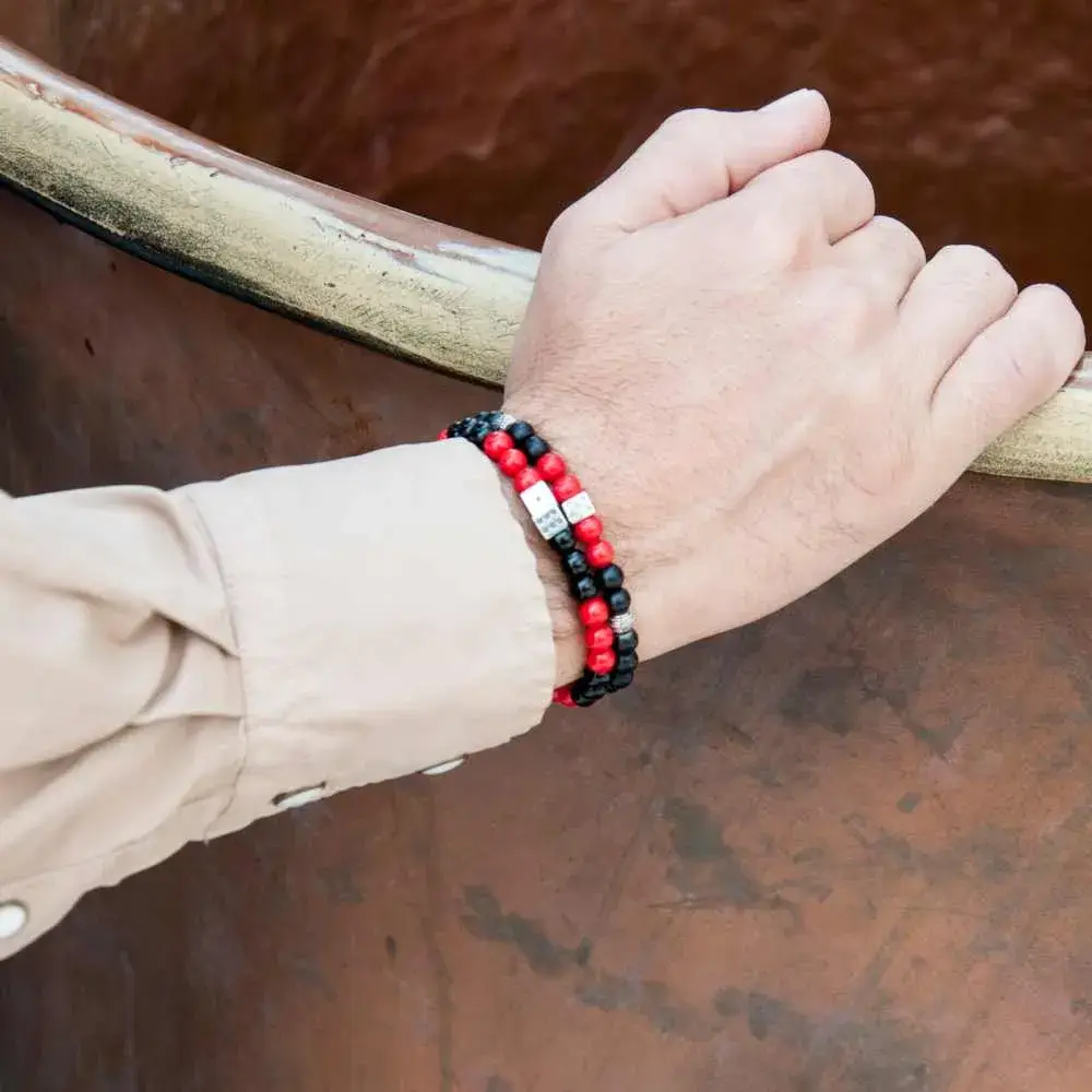 close-up view of a man's hand with red and black bracelet