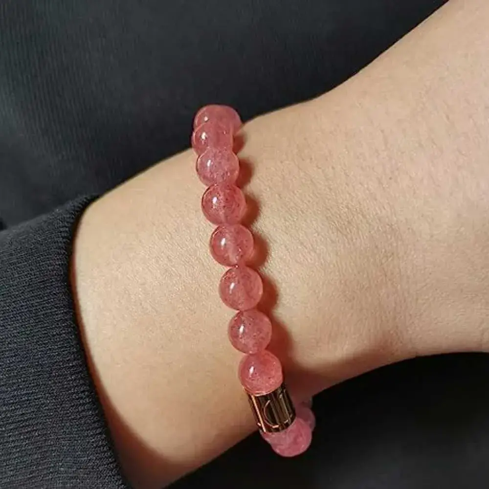 close-up of a wrist with a strawberry quartz bracelet