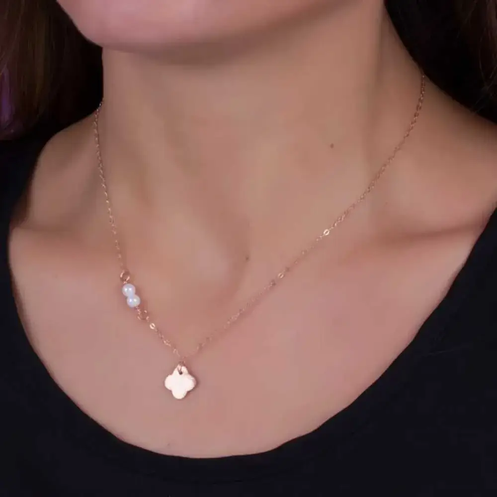 clover pearl necklace on a woman's neck