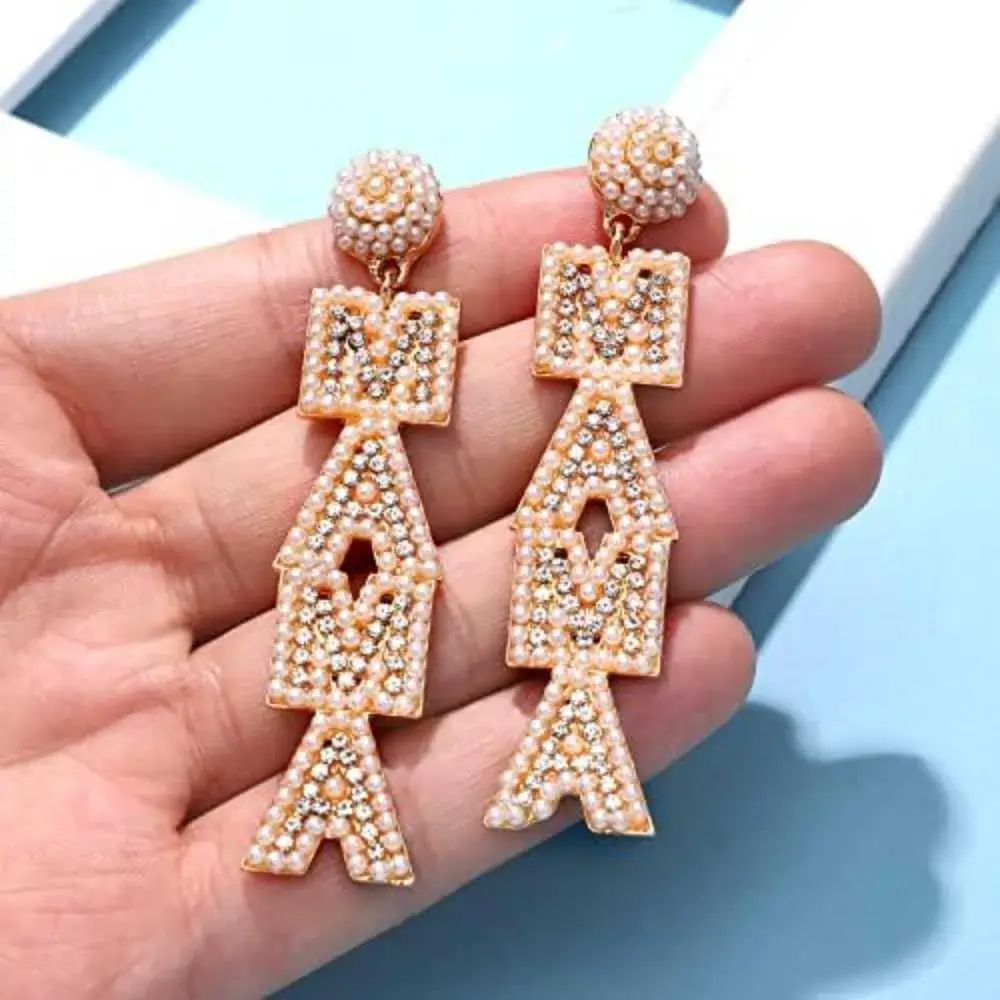 orange mama earrings on the palm