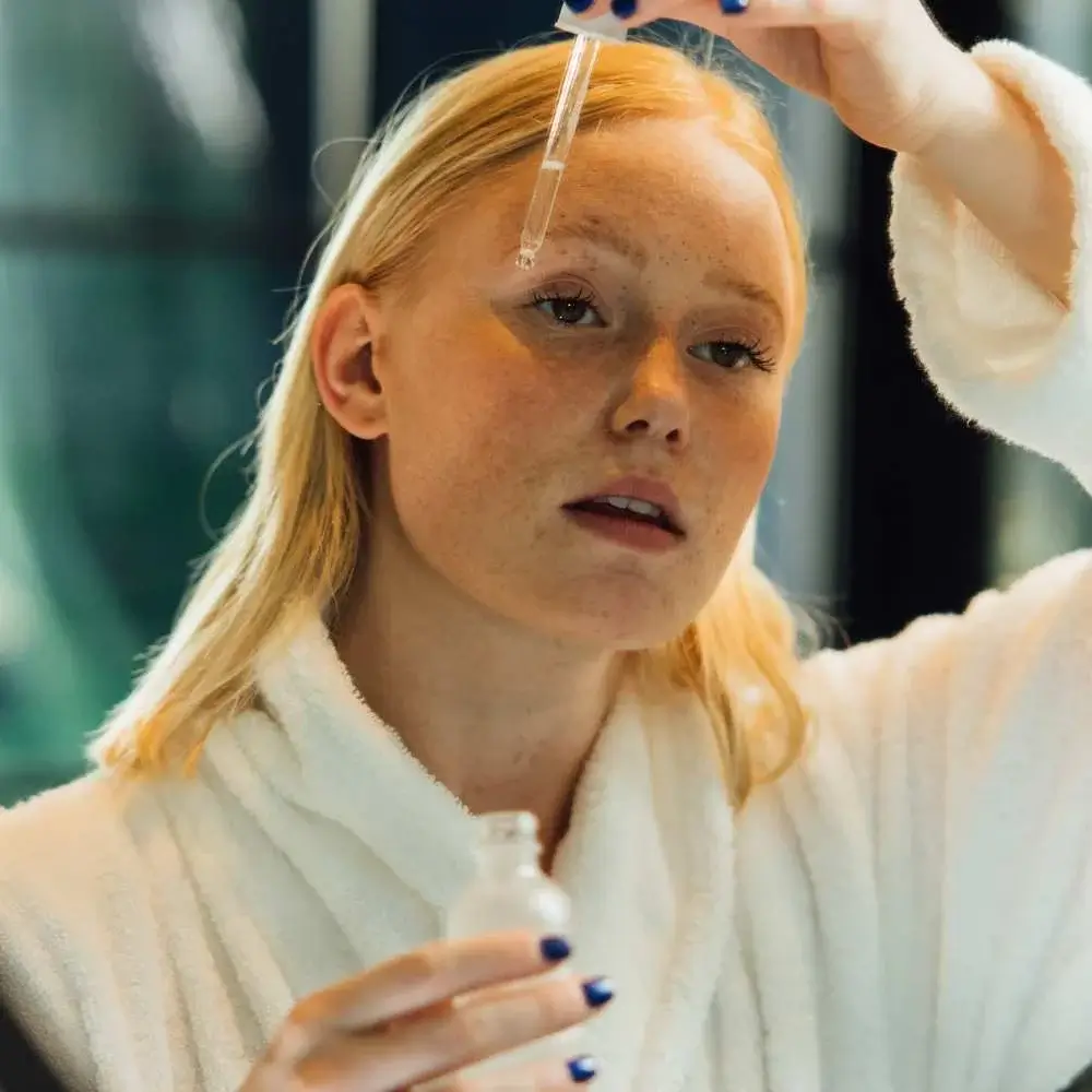 Woman applying Vitamin C serum to her face for skin health