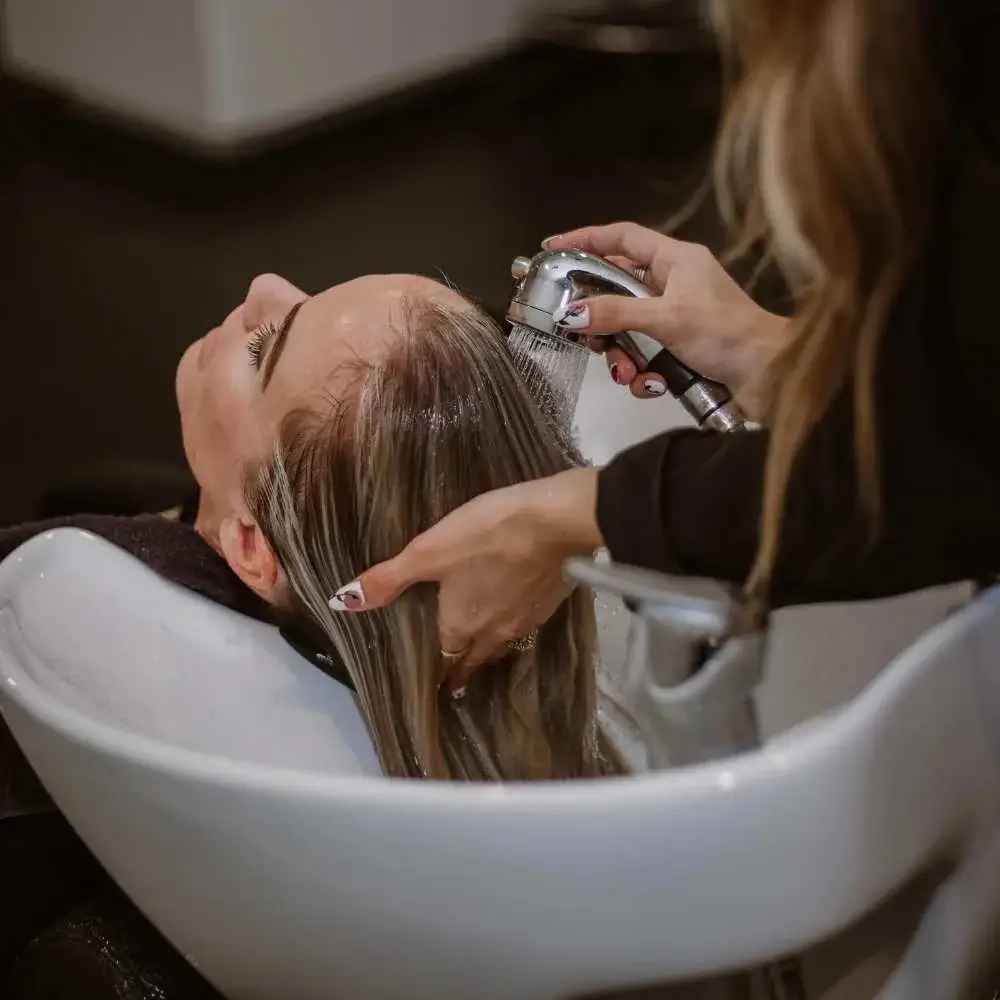 Hair stylist skillfully applying balayage technique on a client's hair