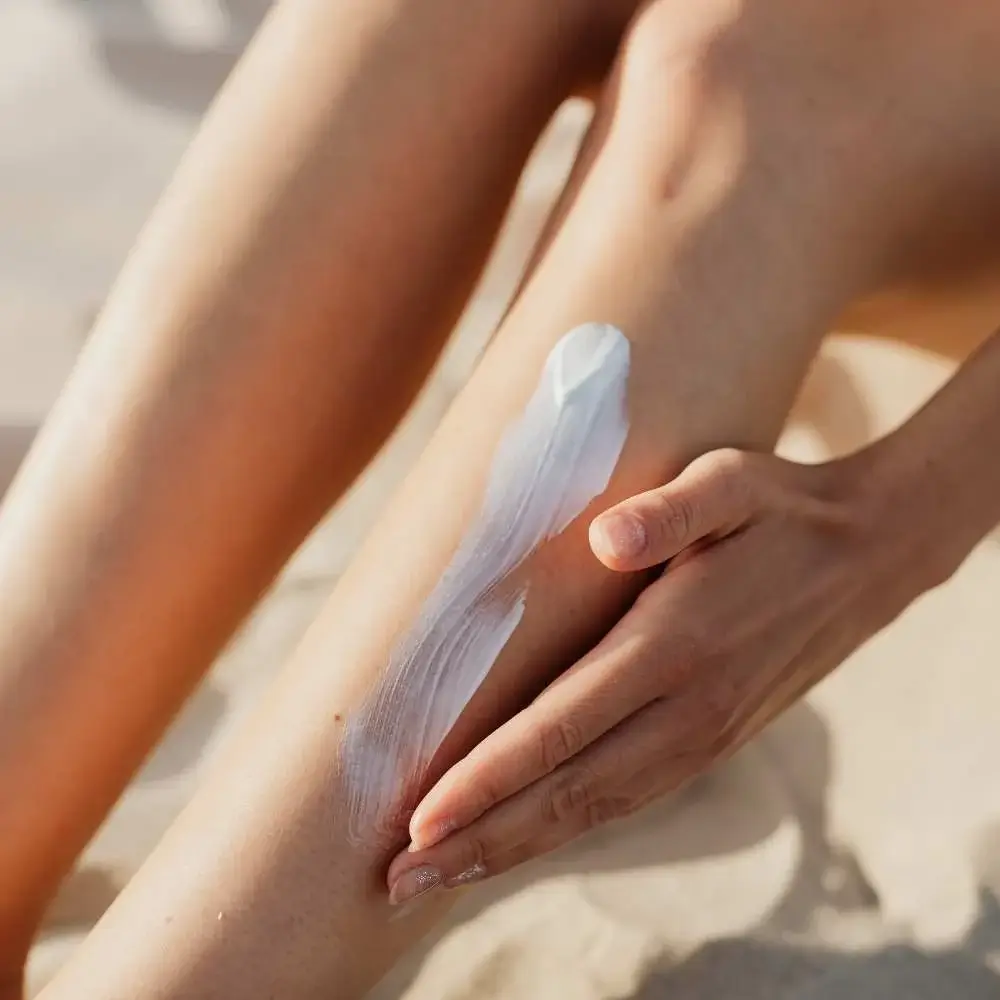 Woman applying sunscreen to her legs