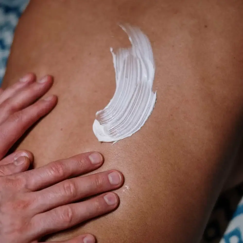 Surfer preparing for the waves by applying durable sunscreen