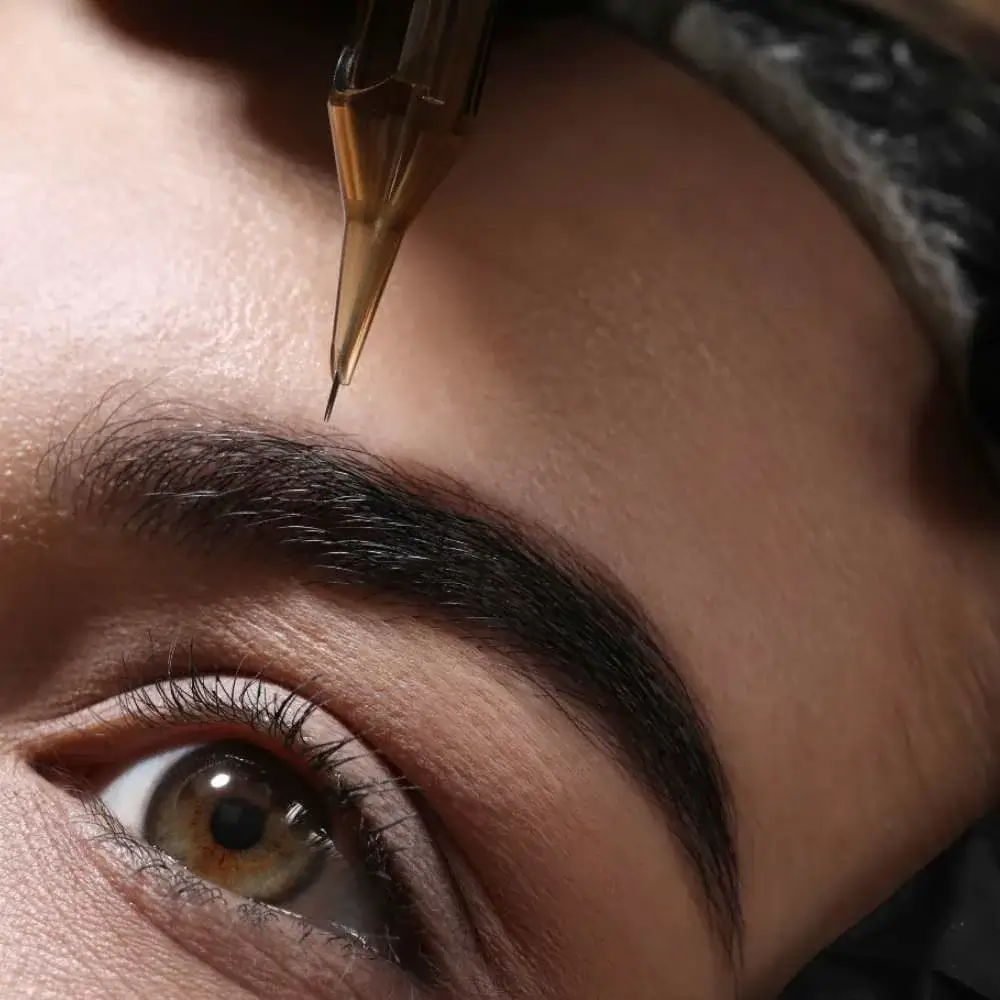 Woman using a microblade eyebrow pen to enhance her brows