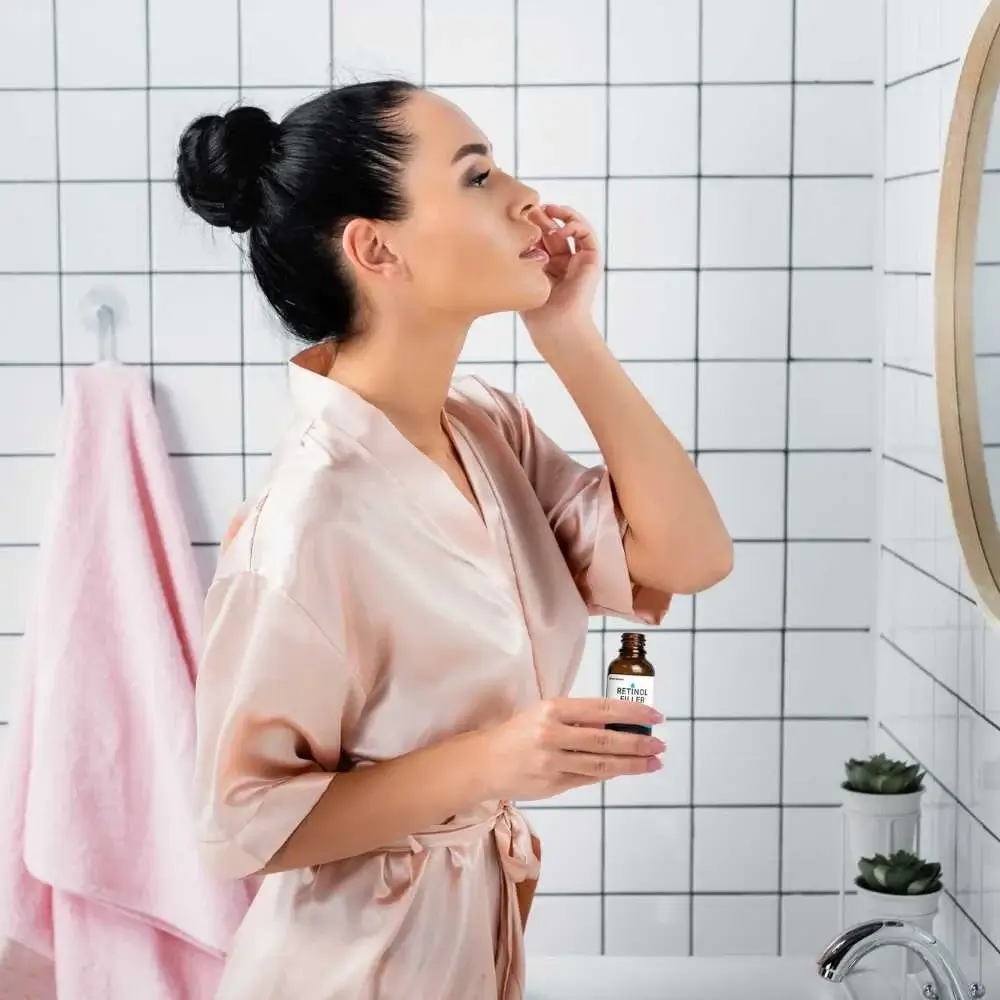 Woman applying a skincare product with both AHA and retinol ingredients