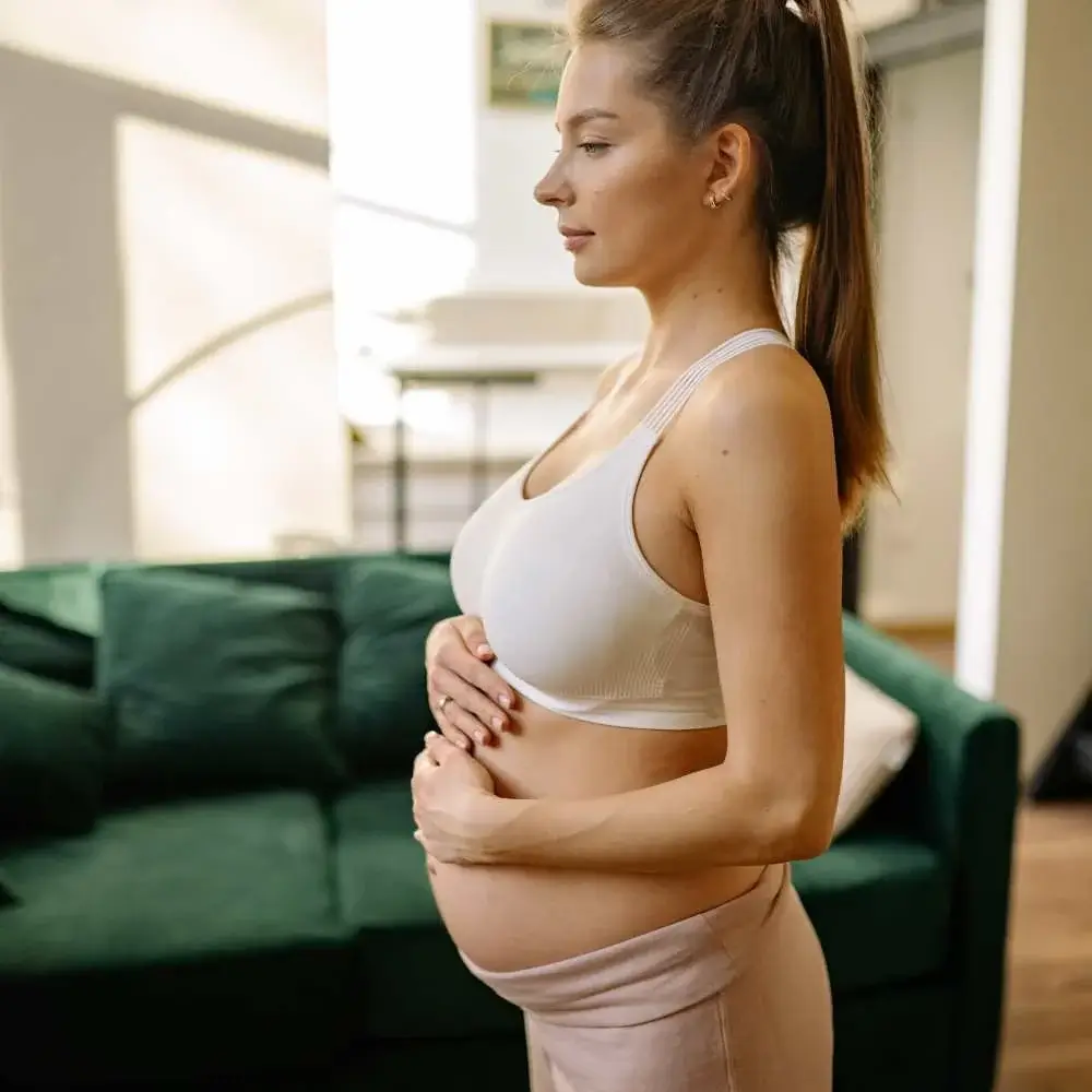 Pregnant woman using natural oils as part of her skincare routine