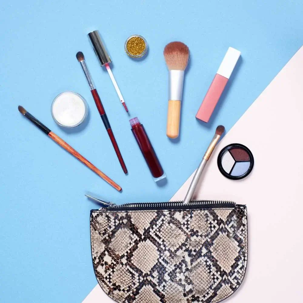 Assortment of beauty products peeking out from a perfect makeup bag