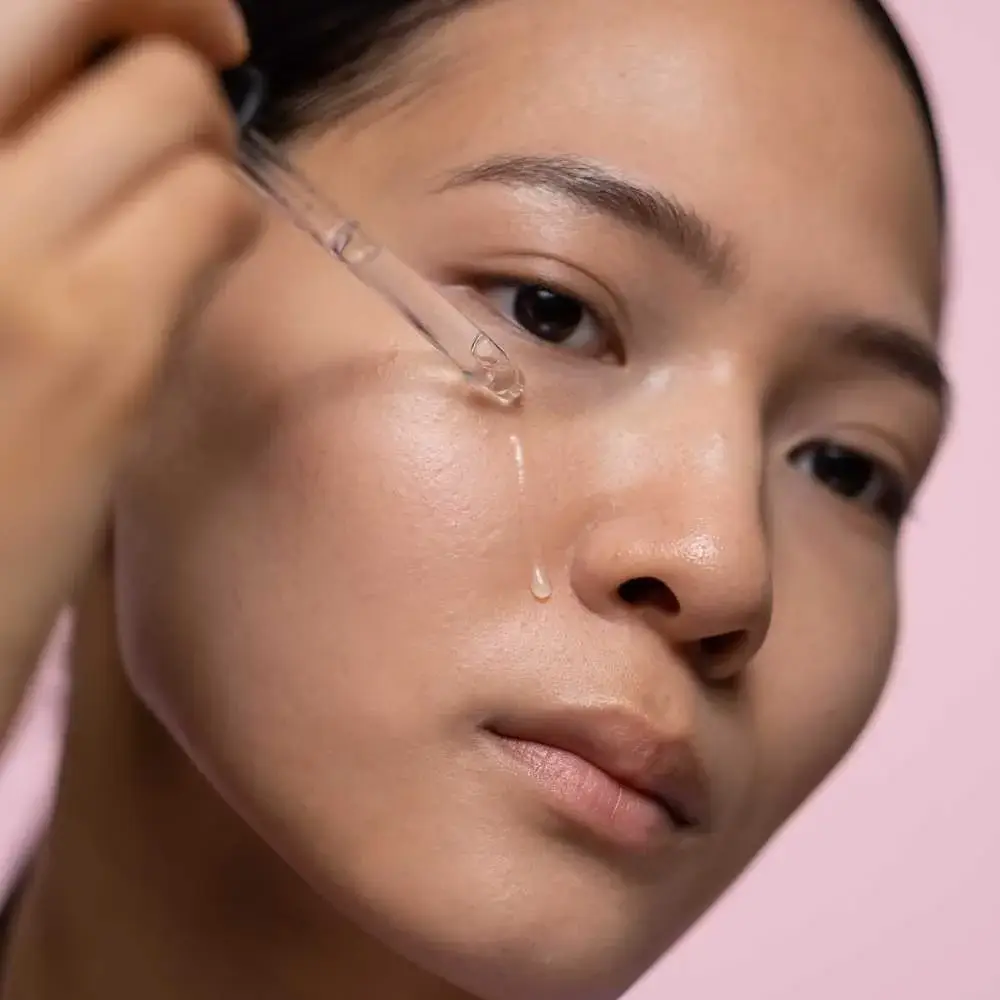 Woman applying a retinol and AHA night cream for enhanced skin renewal
