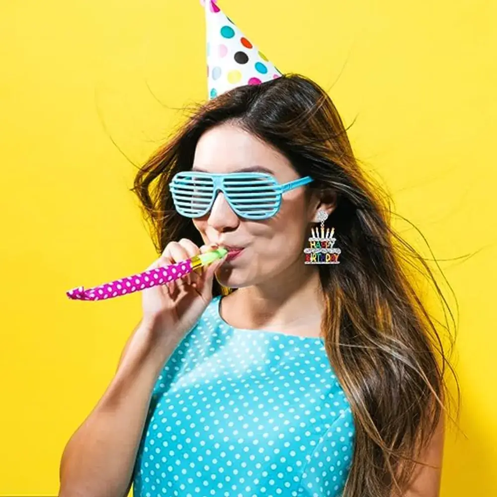 woman wearing a party hat with birthday earrings
