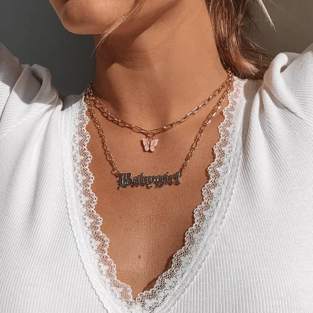 woman wearing a gold babygirl necklace 