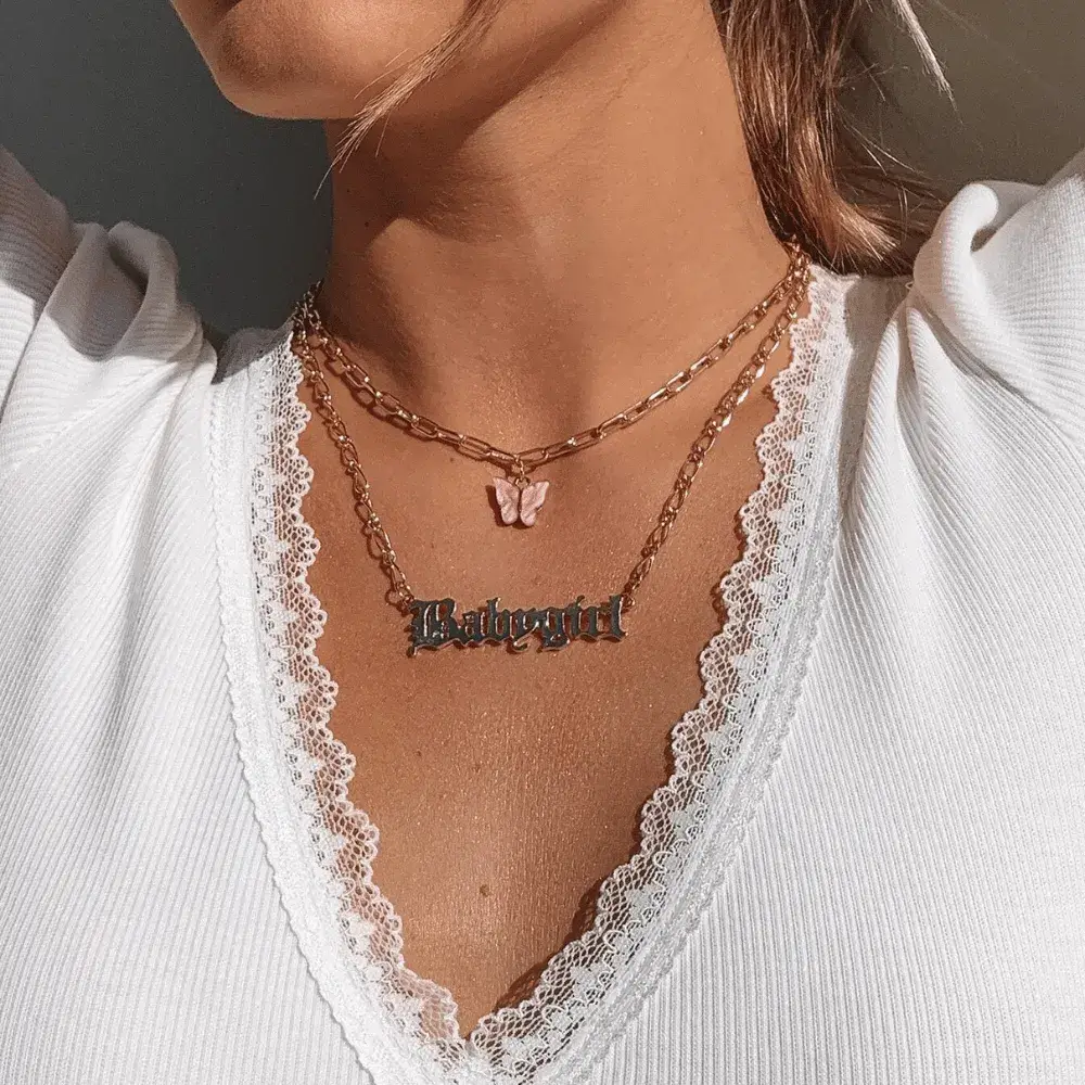 woman wearing a gold babygirl necklace