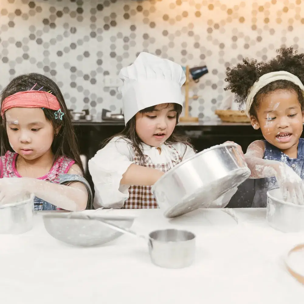 three little girls doing baking in the kitchen