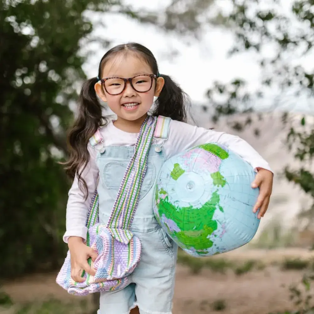 asian young female wearing a sling bag and holding a globe