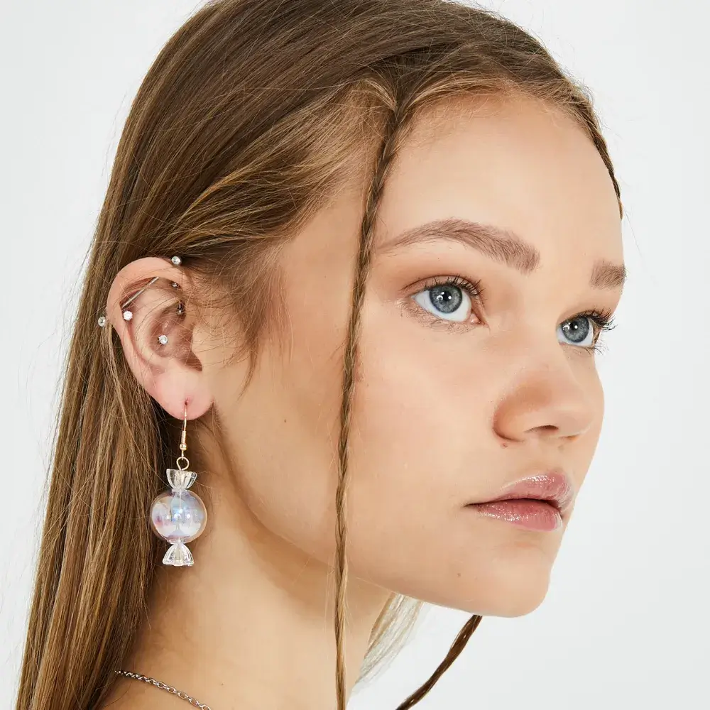 close up portrait of a young woman wearing candy earrings