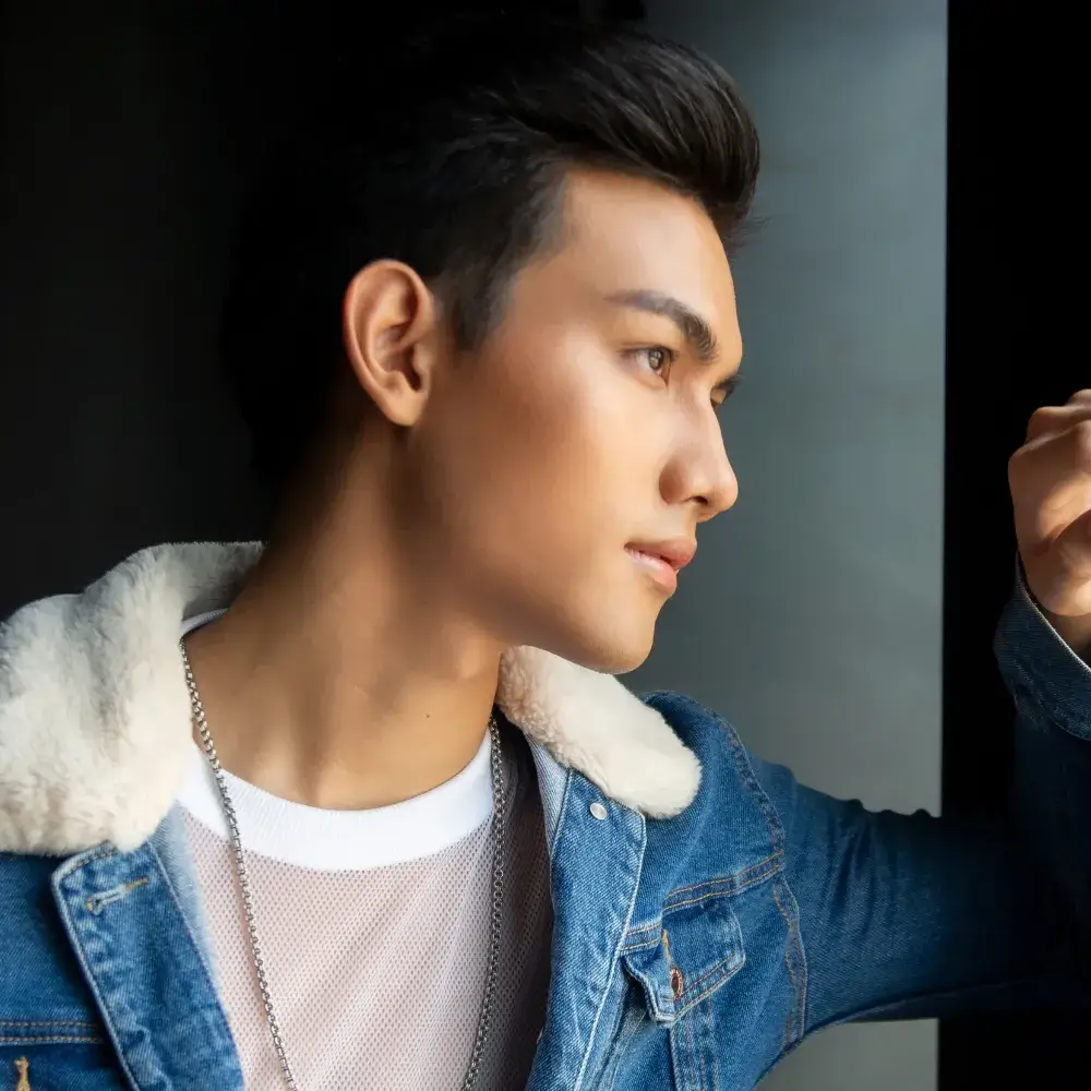 male model wearing a silver necklace and denim jacket