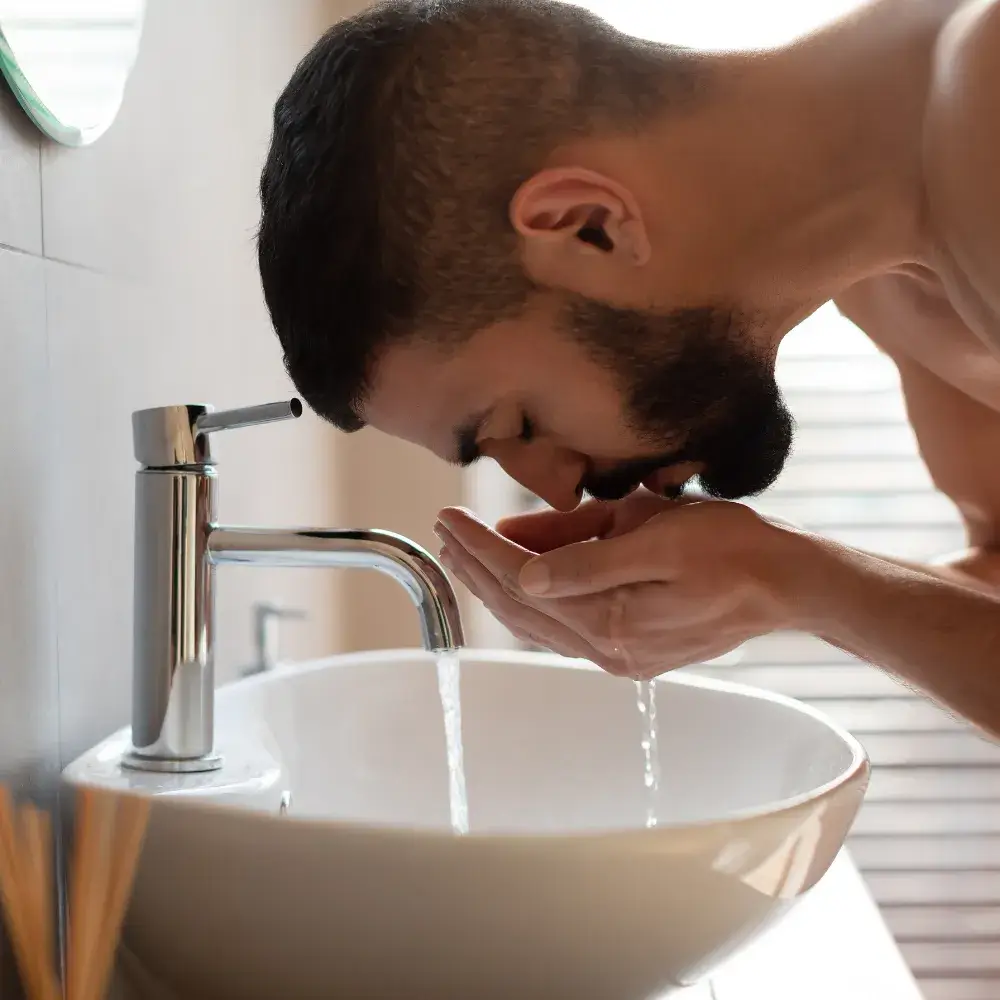 bearded man washing his face
