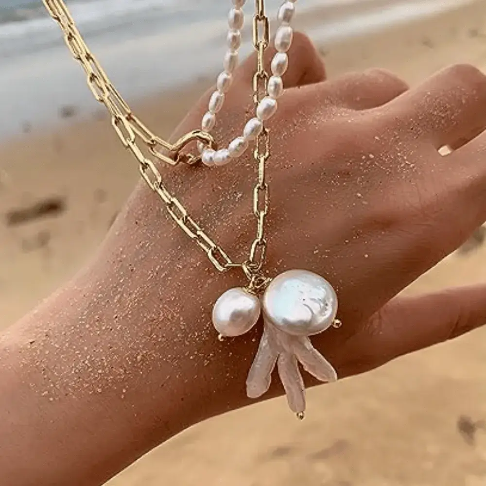 half pearl half chain necklace and a hand
