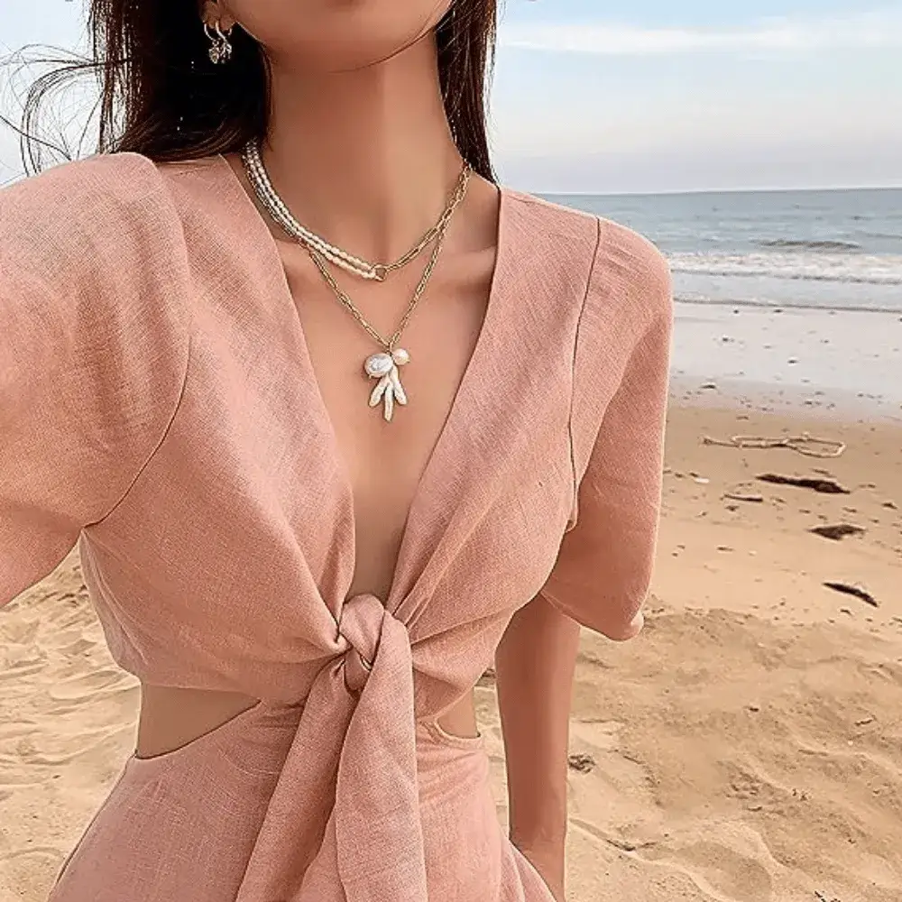 woman at the beach wearing a half pearl half chain necklace