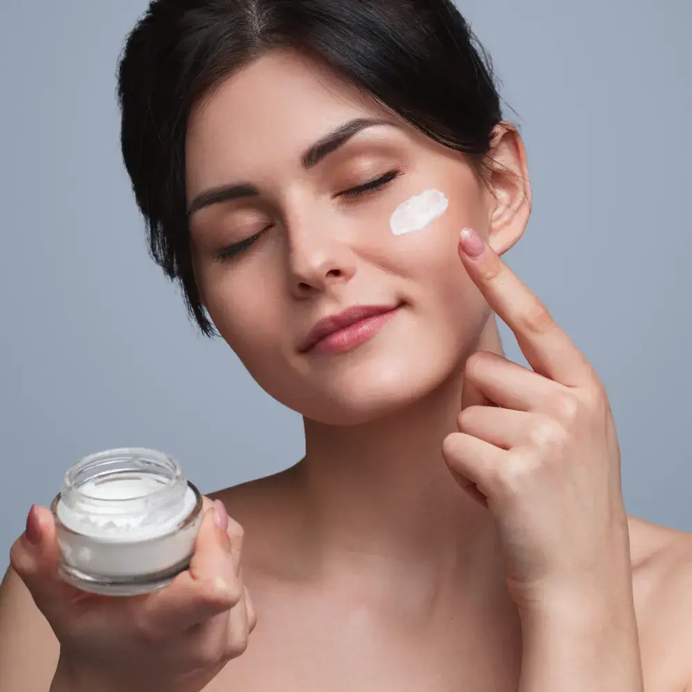 woman applying face moisturizer